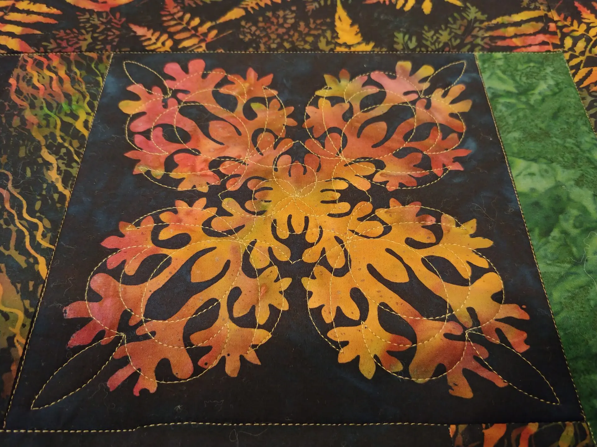 A close up of the leaves on a quilt