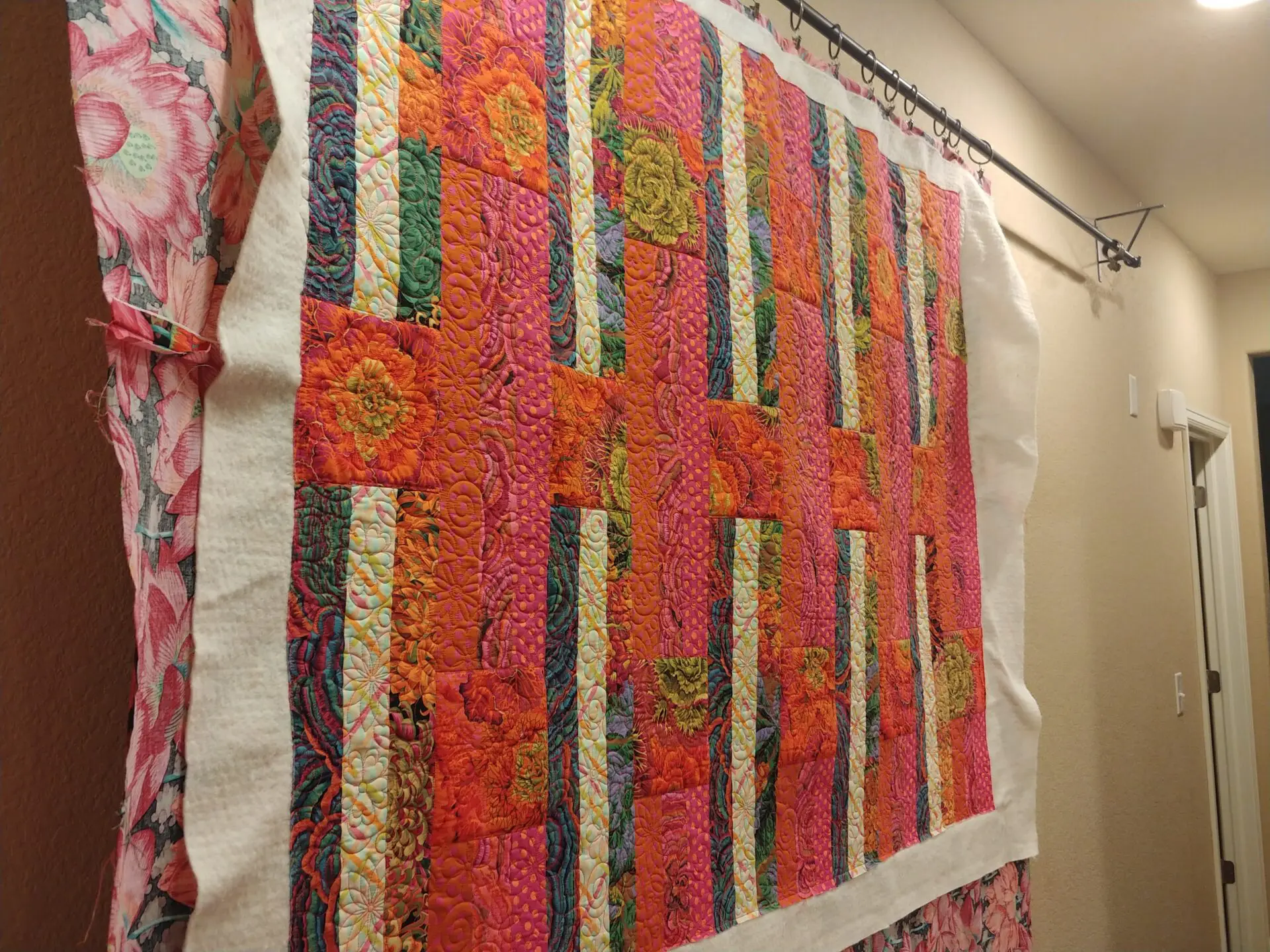 A quilt hanging on the wall of a room.