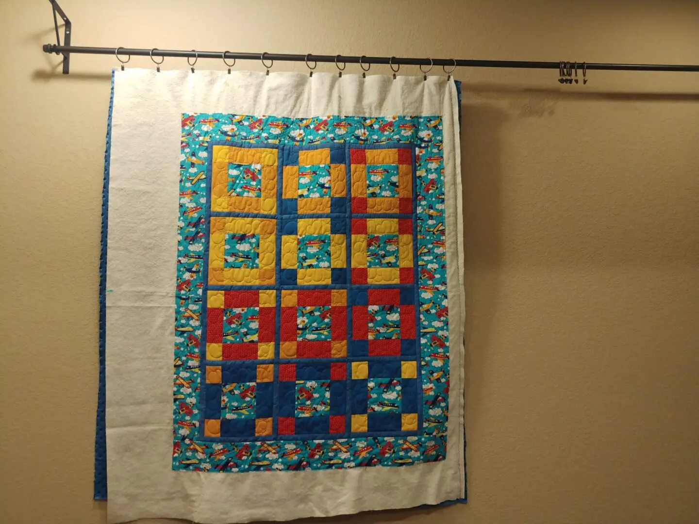 A quilt hanging on the wall of a room.