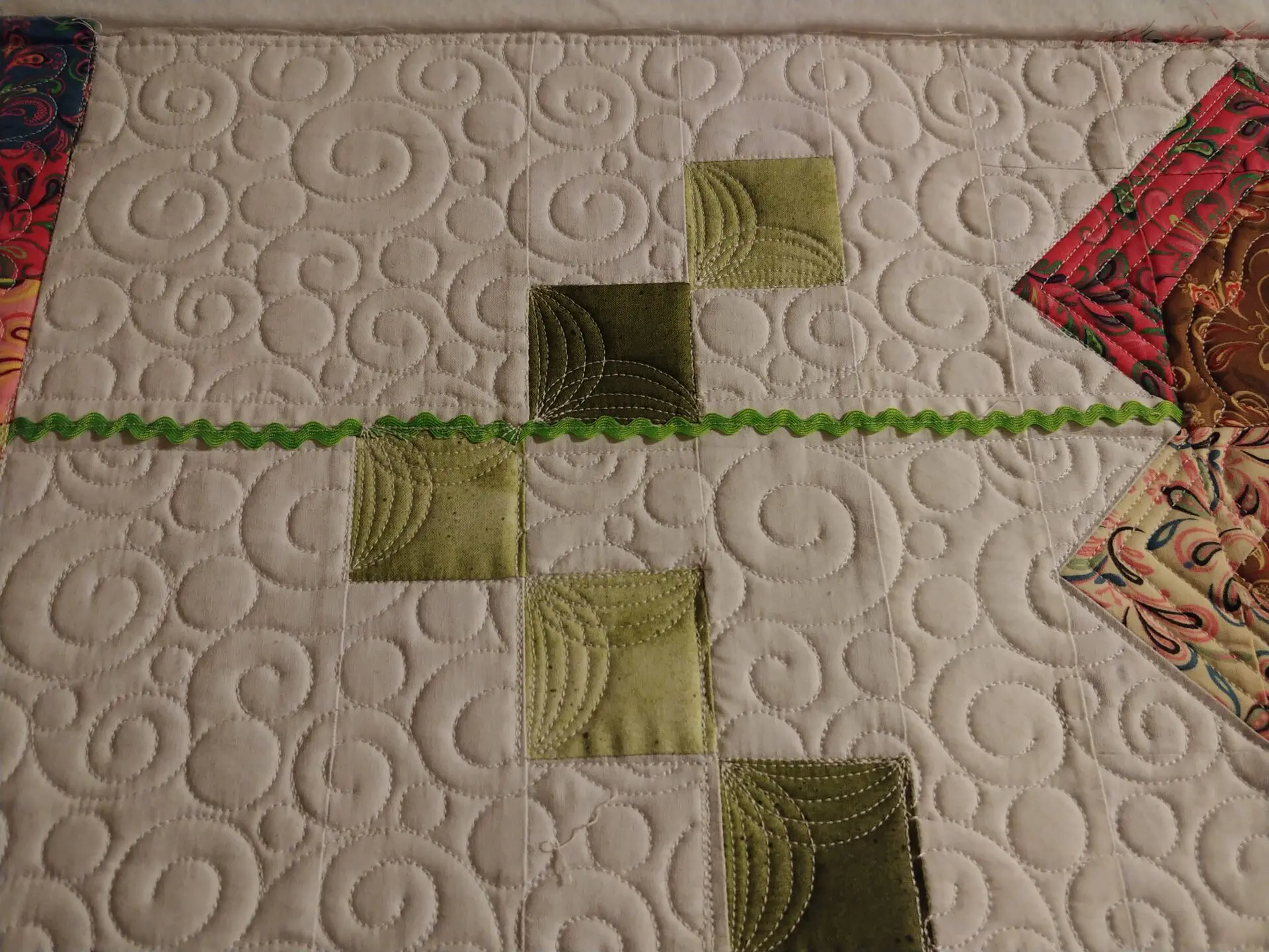 A close up of the green squares on a quilt