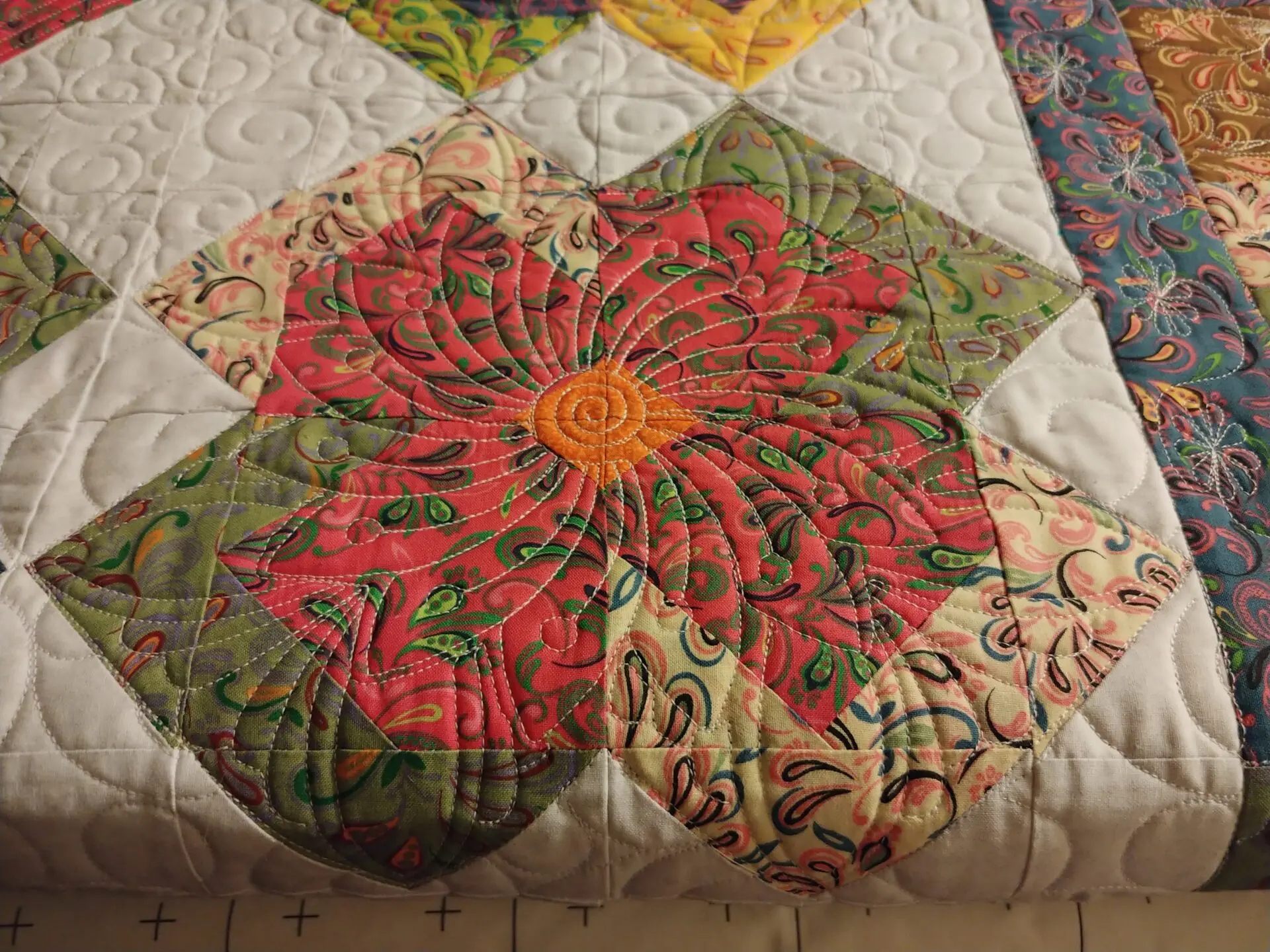 A close up of the flower on a quilt