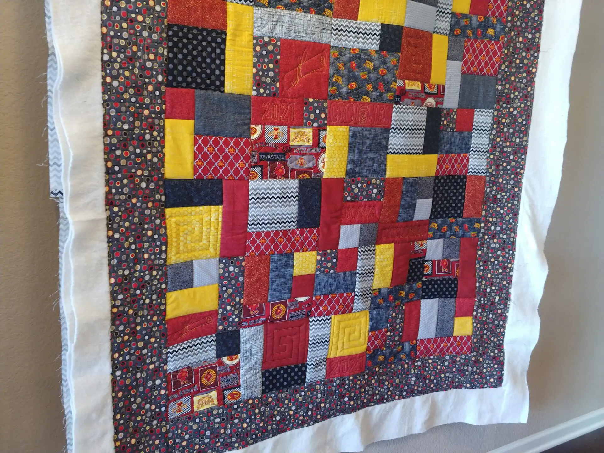 A quilt that is made of different colored fabrics.