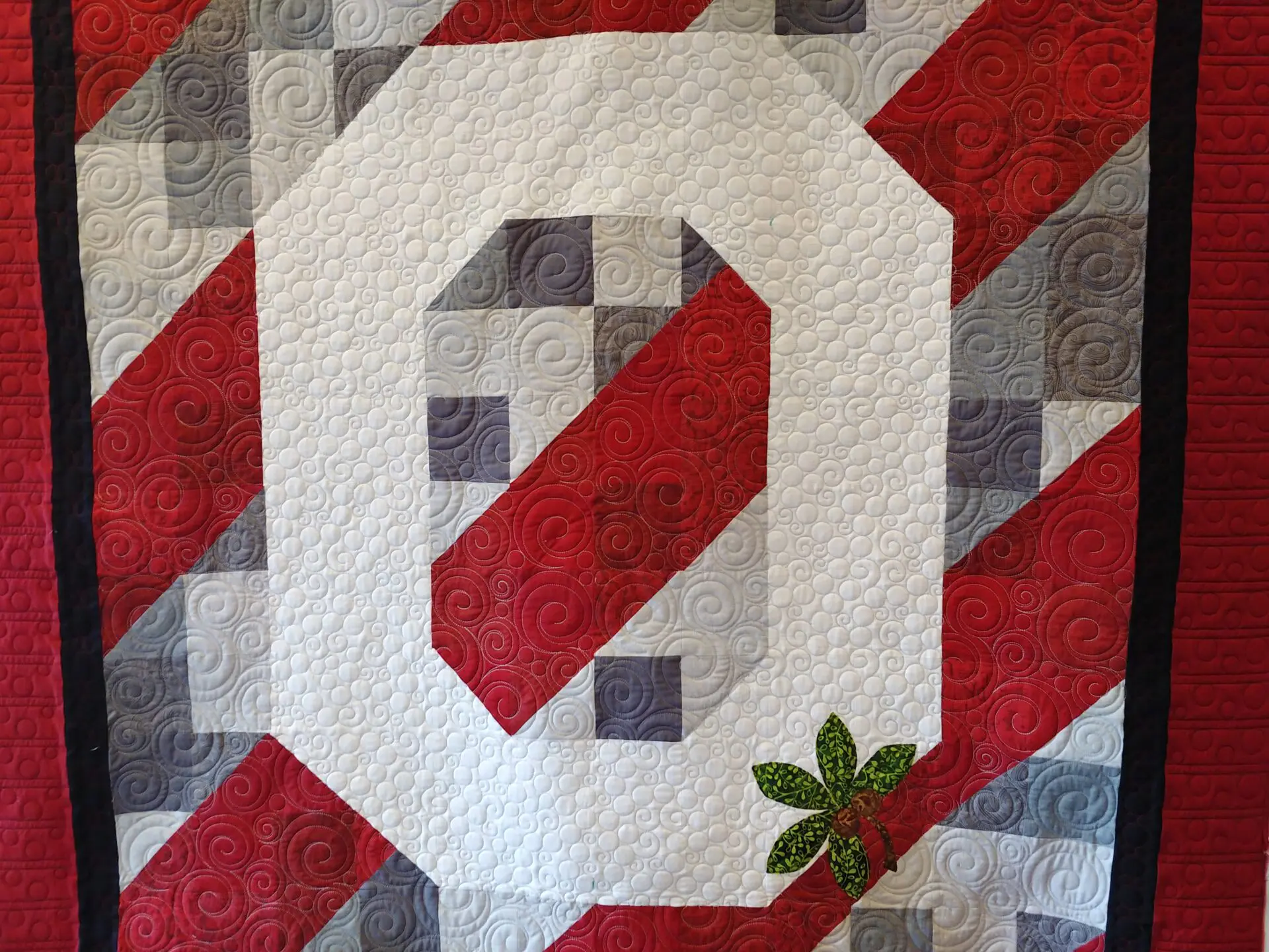 A quilt with the letter o on it.