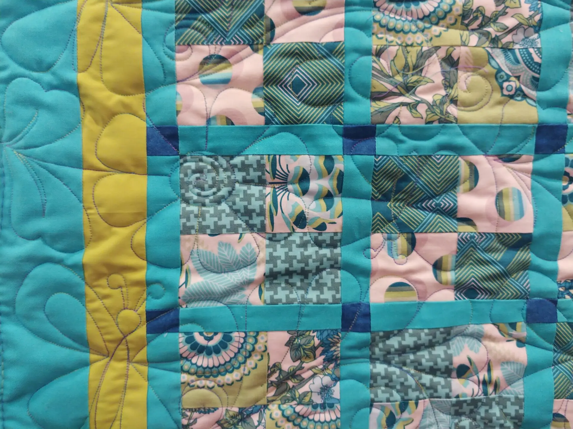 A close up of the quilt with blue and yellow squares