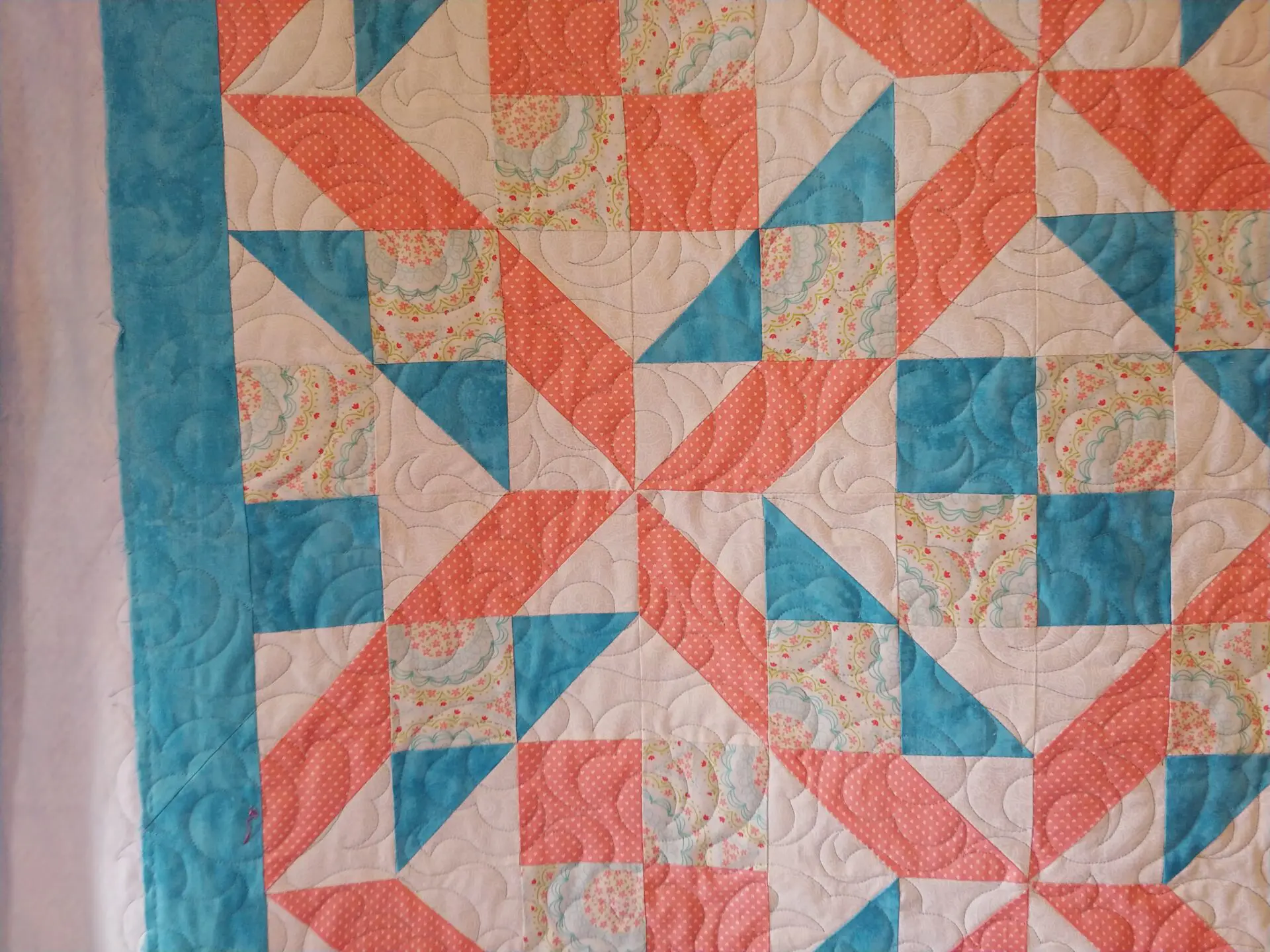 A quilt with an orange and blue pattern.