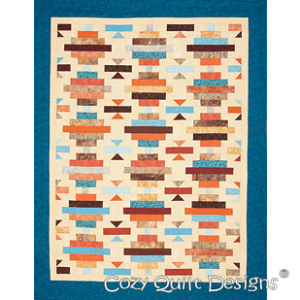 A quilt with a blue border and an orange, brown, white and black design.