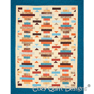 A quilt with a blue border and an orange, brown, white and black design.