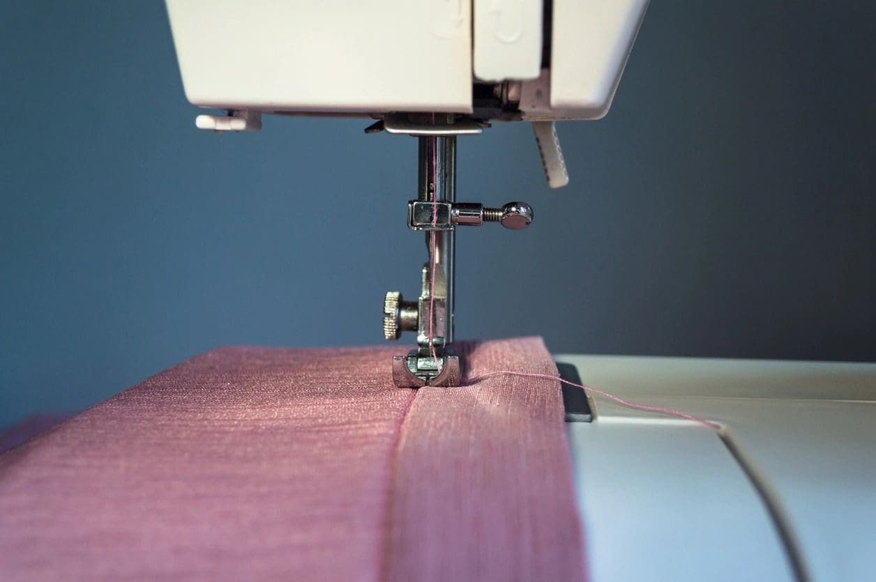 A sewing machine with pink fabric on it.