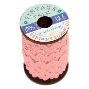 Pink scalloped trim ribbon on a spool.