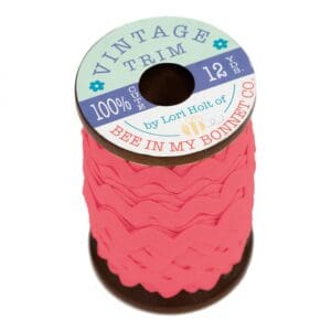 A spool of pink vintage cotton lace trim.