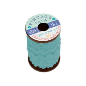 A spool of teal-colored ric rac trim with a label on top.