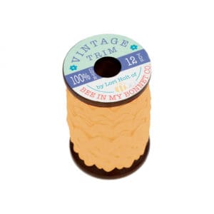 A spool of DMC embroidery floss thread in yellow.