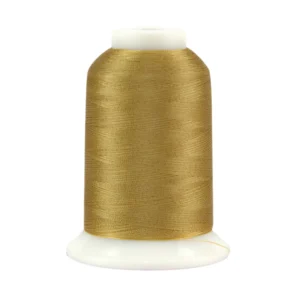 Gold sewing thread spool on white background.