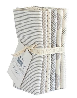 Neutral patterned quilting fabric bundle tied with ribbon