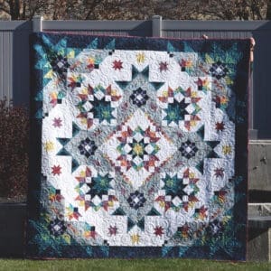 Colorful geometric quilt held outdoors
