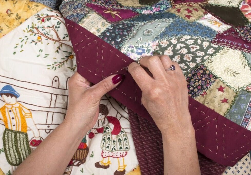 A person is sewing on the quilt